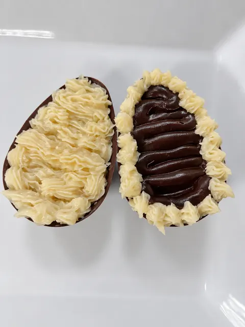Duas metades de chocolate com acabamentos feitos com bico.
